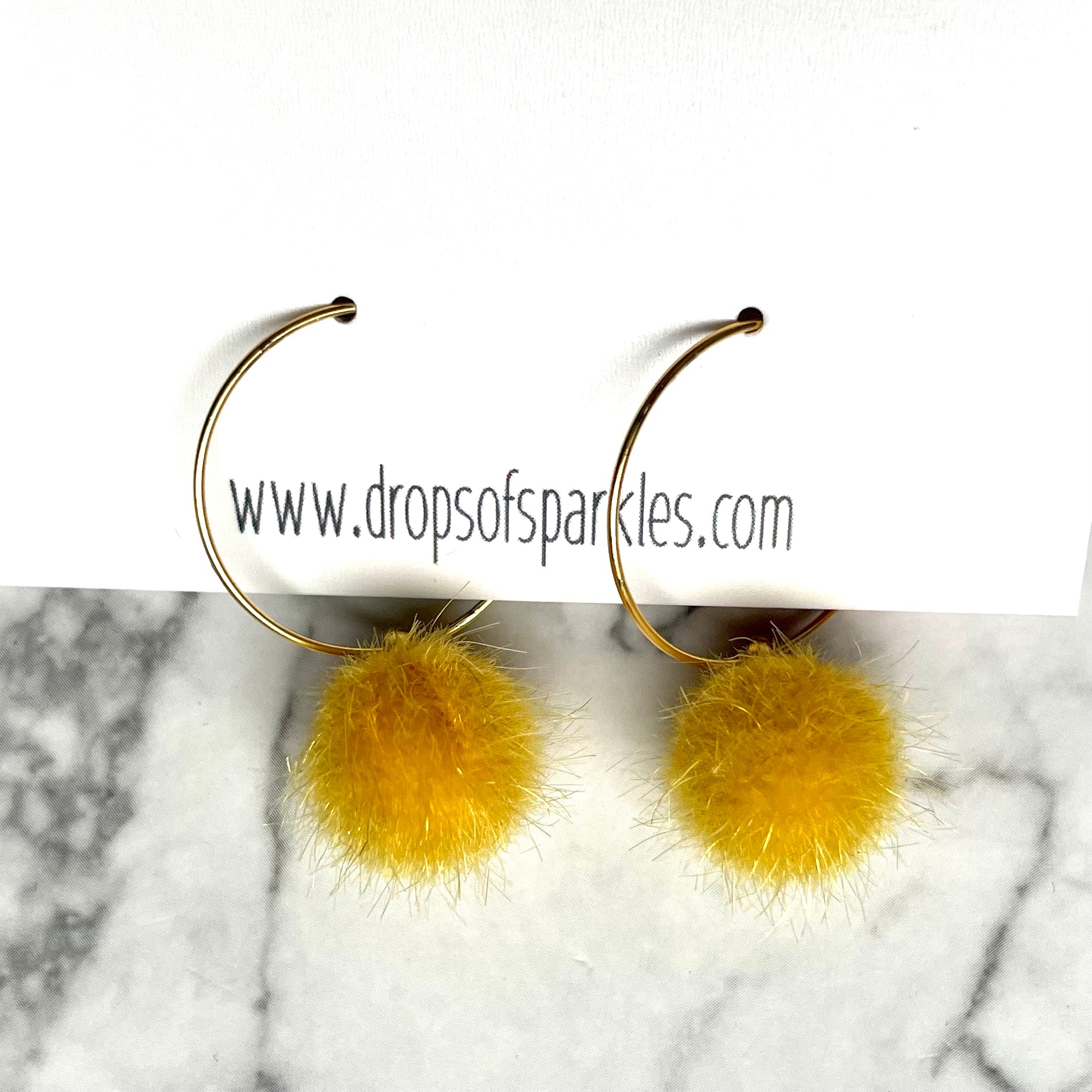 20mm round 24k shiny gold plated  "hoops" with fun little canary yellow fuzzy pom poms attached